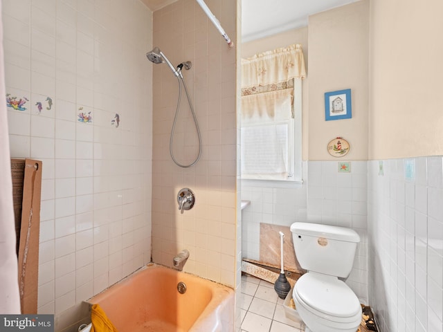 bathroom featuring tile walls, shower / bath combination, toilet, wainscoting, and tile patterned flooring