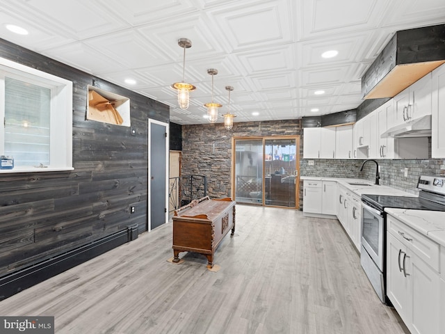 kitchen featuring an ornate ceiling, pendant lighting, white cabinets, under cabinet range hood, and stainless steel electric range