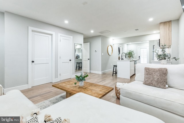 living room with sink and light hardwood / wood-style floors