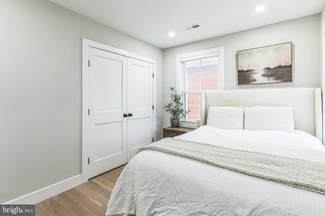 bedroom with light hardwood / wood-style floors and a closet