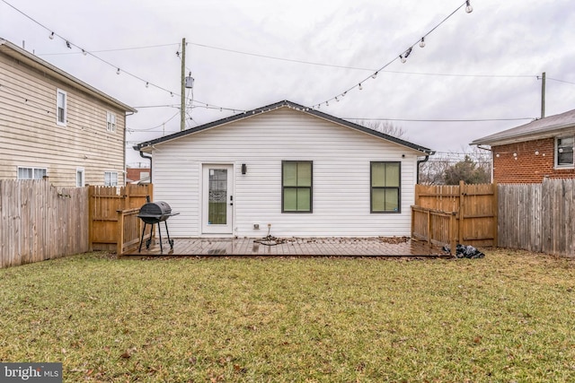 rear view of house with a deck and a lawn