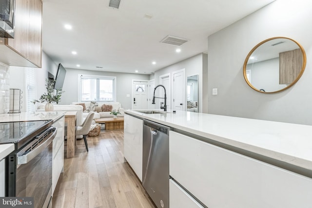 kitchen featuring sink, light wood-type flooring, and appliances with stainless steel finishes