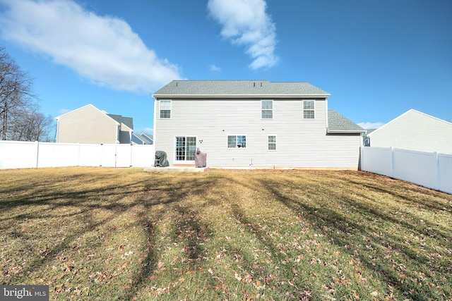 rear view of house featuring a lawn