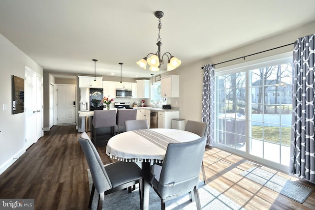 dining room with a healthy amount of sunlight, a chandelier, and hardwood / wood-style floors