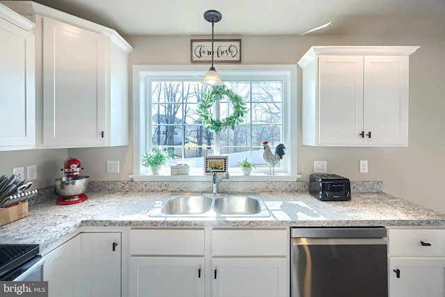 kitchen with pendant lighting, sink, white cabinetry, stainless steel appliances, and light stone countertops