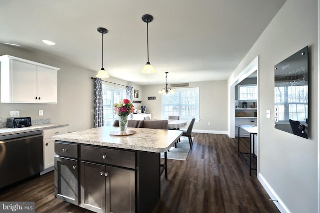 kitchen with dark hardwood / wood-style floors, decorative light fixtures, white cabinetry, dishwasher, and a center island