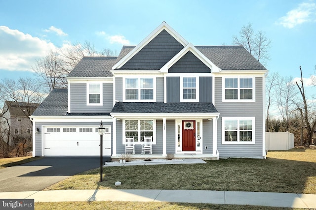 view of front of house with a garage, covered porch, and a front lawn