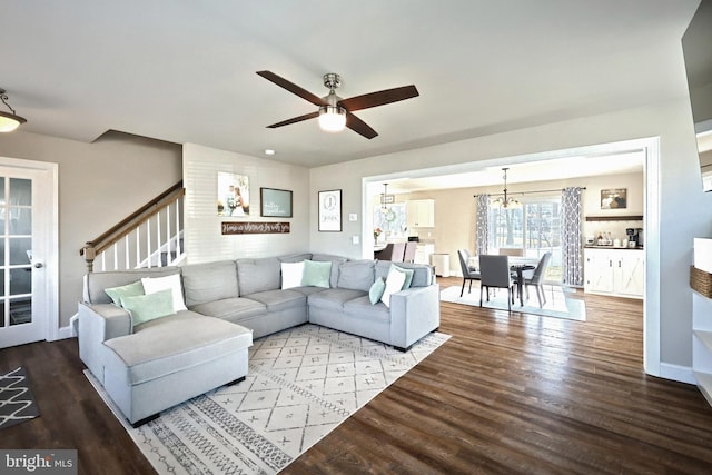 living room with hardwood / wood-style flooring and ceiling fan with notable chandelier