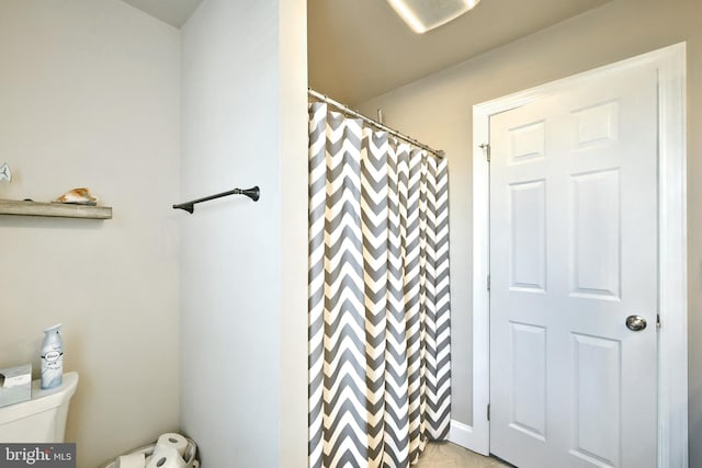 bathroom featuring a shower with curtain and toilet