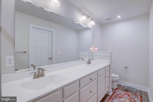 bathroom with wood-type flooring, toilet, and vanity