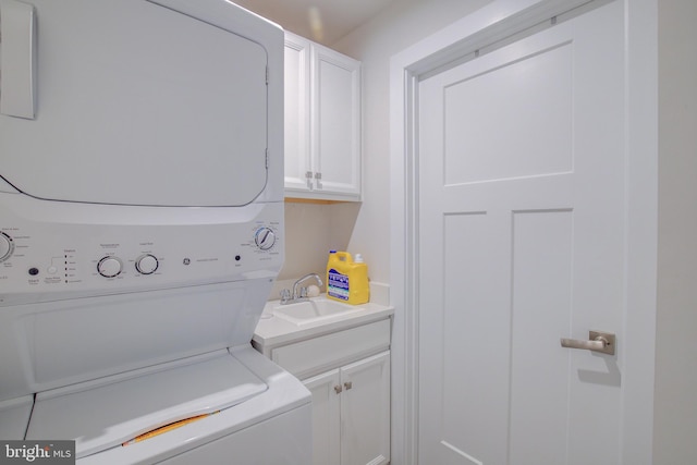 laundry room with cabinets, sink, and stacked washer and clothes dryer