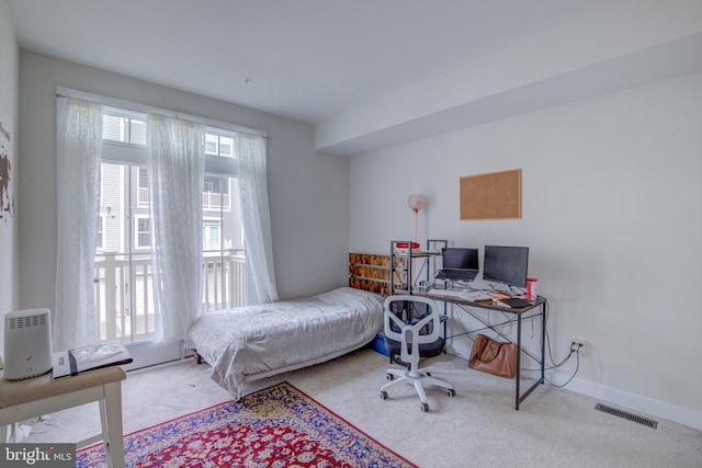 bedroom with multiple windows and light colored carpet