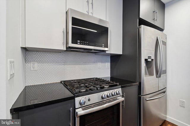 1501 N 31st St Unit 205, Philadelphia, PA 19121 - kitchen featuring appliances with stainless steel finishes, dark countertops, white cabinetry, and tasteful backsplash