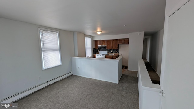 kitchen with white gas range, decorative backsplash, carpet, a baseboard heating unit, and kitchen peninsula