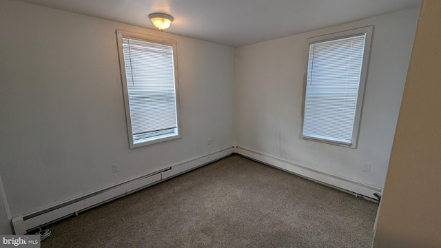 spare room with baseboard heating and carpet