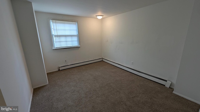 carpeted empty room featuring a baseboard heating unit