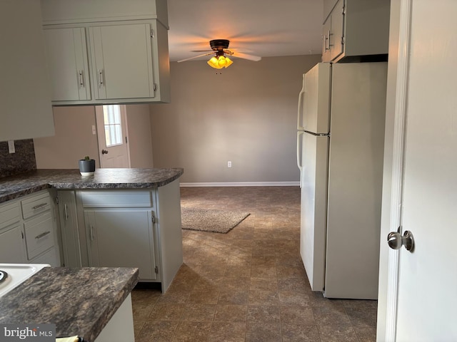 kitchen featuring white fridge, white cabinets, ceiling fan, and kitchen peninsula