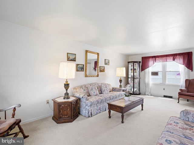 carpeted living area featuring visible vents and baseboards