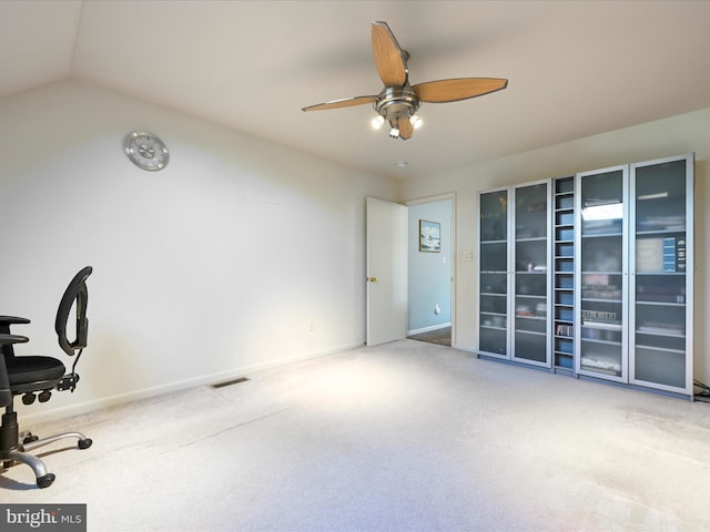 home office featuring vaulted ceiling, ceiling fan, and carpet