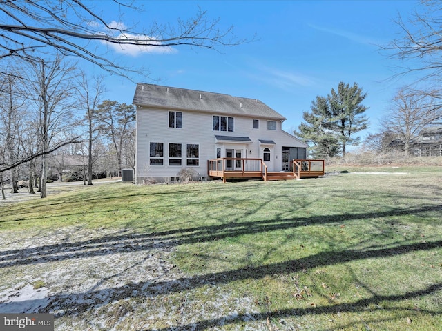 rear view of house with a wooden deck and a lawn