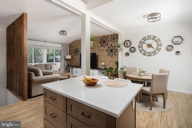 kitchen with a center island, vaulted ceiling, and light wood-type flooring