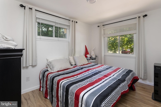 bedroom featuring multiple windows and light hardwood / wood-style flooring