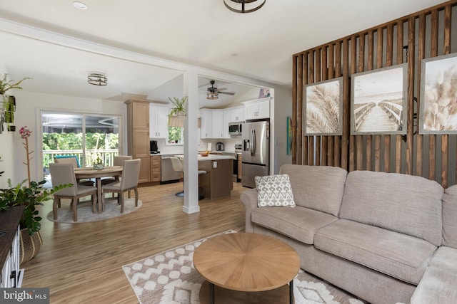 living room with vaulted ceiling and light wood-type flooring