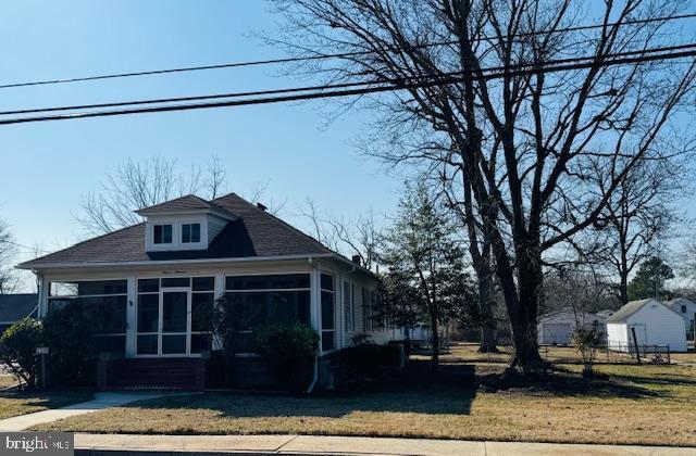 exterior space featuring a front yard and a sunroom