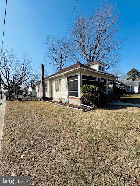 view of side of home with a yard