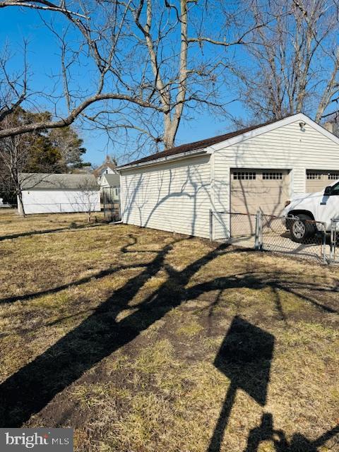 exterior space with a garage, a lawn, and an outdoor structure