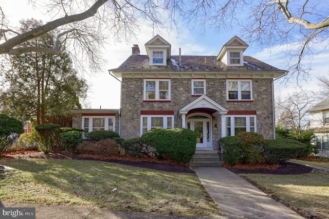 colonial home featuring a front lawn