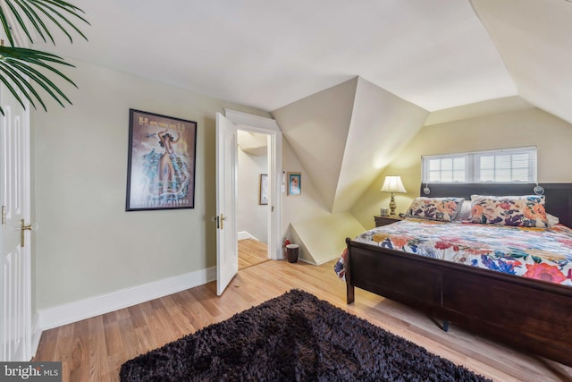 bedroom featuring vaulted ceiling and light hardwood / wood-style floors