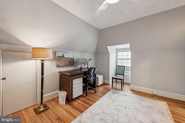 office featuring ceiling fan, lofted ceiling, light hardwood / wood-style flooring, and a textured ceiling