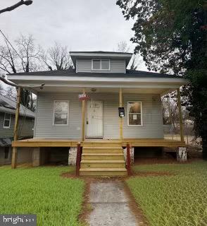 bungalow-style home with a porch and a front lawn