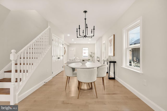 dining room featuring recessed lighting, light wood-style floors, a chandelier, baseboards, and stairs