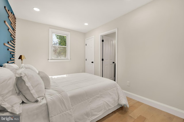 bedroom with recessed lighting, light wood-style flooring, and baseboards