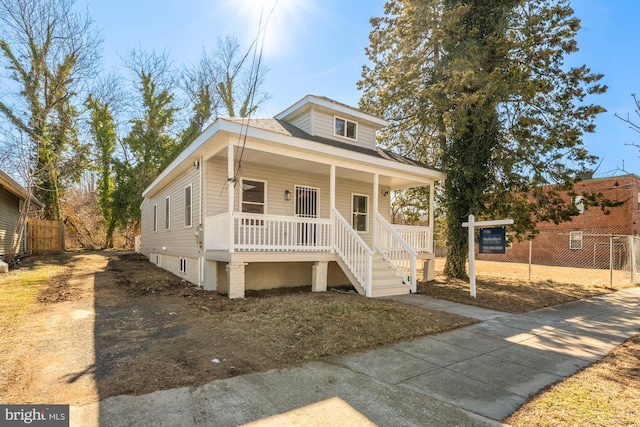 bungalow featuring covered porch and fence