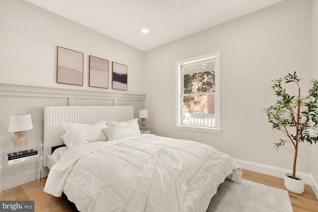 bedroom with recessed lighting, wood finished floors, and baseboards