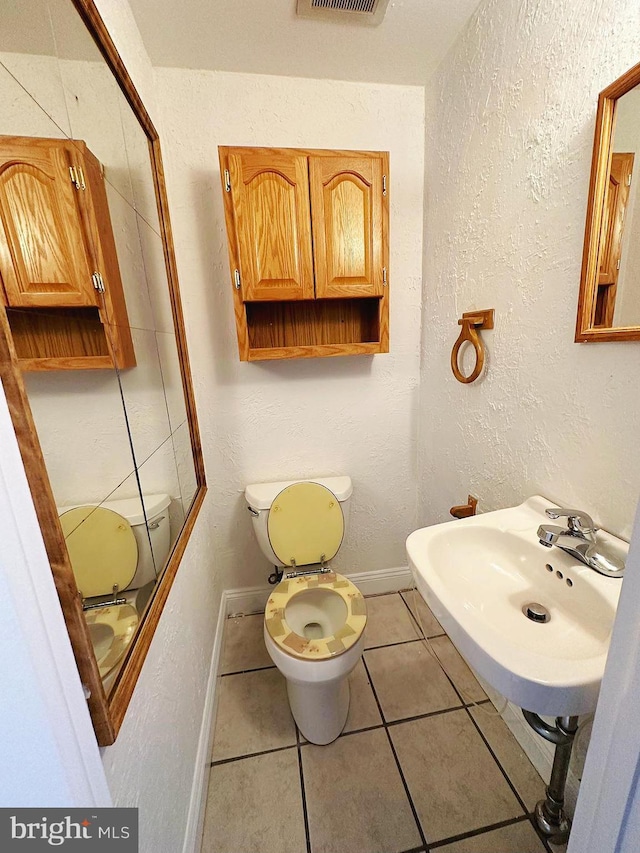 bathroom featuring sink, tile patterned floors, and toilet