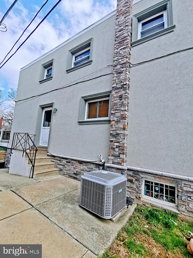 rear view of property with central AC and a patio area