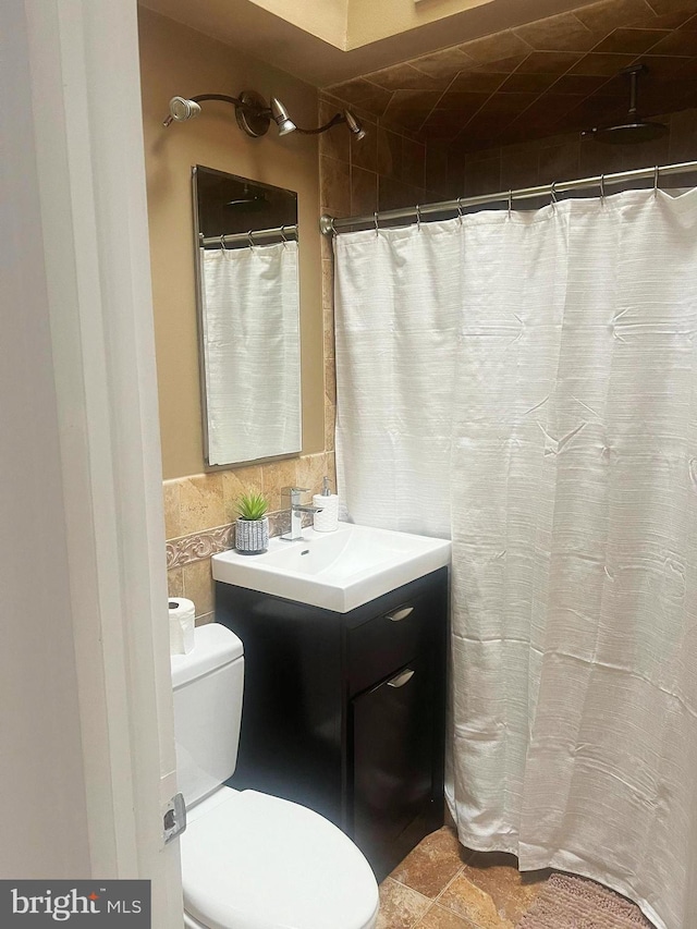 bathroom featuring a shower with curtain, vanity, tile walls, and toilet