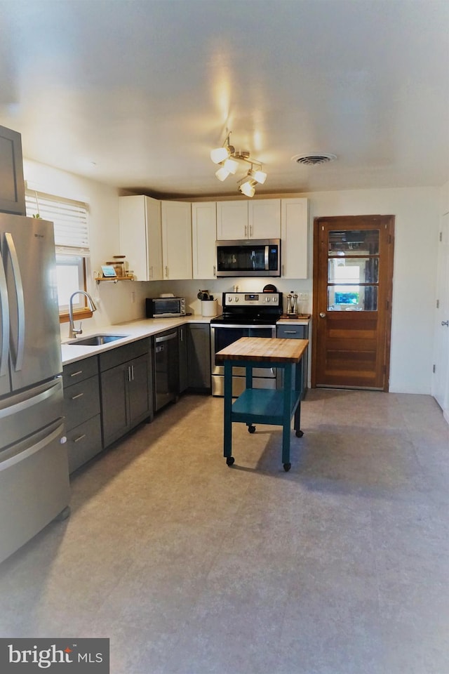 kitchen featuring sink, white cabinets, and appliances with stainless steel finishes