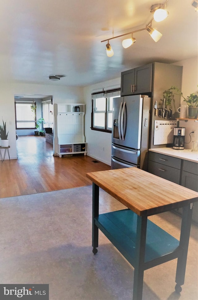 kitchen with stainless steel fridge with ice dispenser, rail lighting, and dark hardwood / wood-style floors