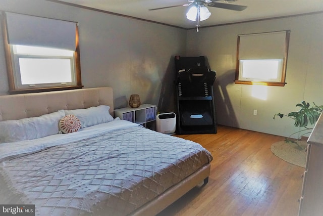 bedroom with crown molding, light hardwood / wood-style floors, and ceiling fan