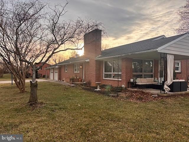 property exterior at dusk featuring cooling unit, an outdoor living space, and a lawn