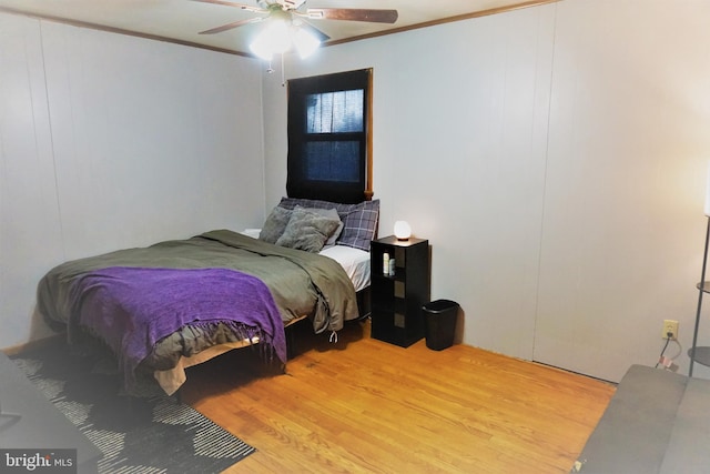 bedroom with crown molding, light hardwood / wood-style floors, and ceiling fan