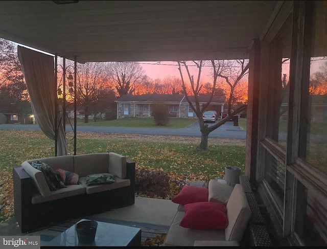 patio terrace at dusk featuring a yard