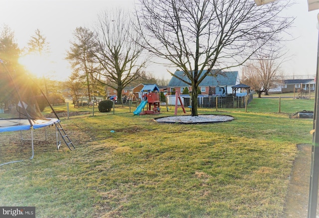 view of yard featuring a playground and a trampoline