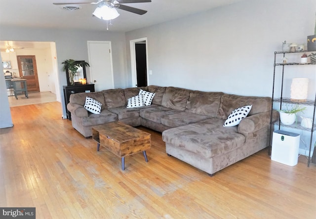 living room featuring ceiling fan and light hardwood / wood-style floors