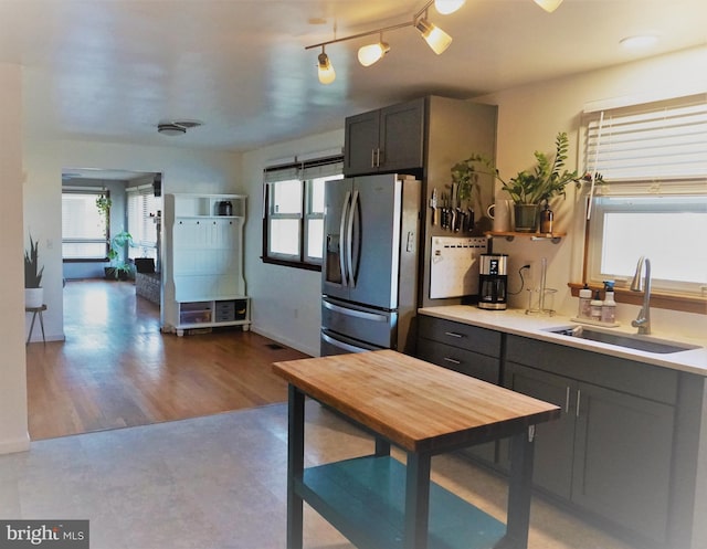 kitchen featuring plenty of natural light, sink, hardwood / wood-style floors, and stainless steel fridge with ice dispenser